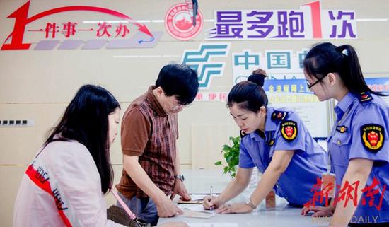↑7月1日,宁远县市监局窗口,工作人员在受理企业申办登记。最近,该县推行“一件事一次办”改革,实现企业和群众办事线上“一次登录、一网通办”,线下“只进一扇门”。黄建军 摄