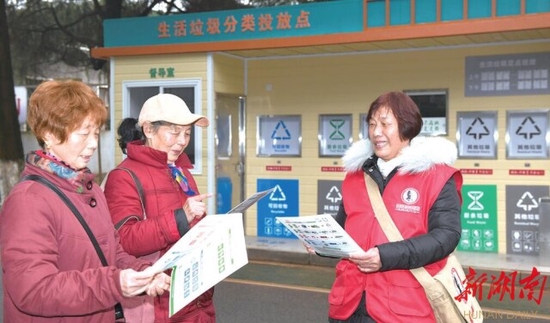 (湘陵社区的网格员正在引导居民正确进行垃圾分类。 范远志 摄)