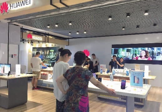 5月18日晚，数名消费者在苏宁五一广场云店华为柜台选购商品。 记者 黄亚苹 摄