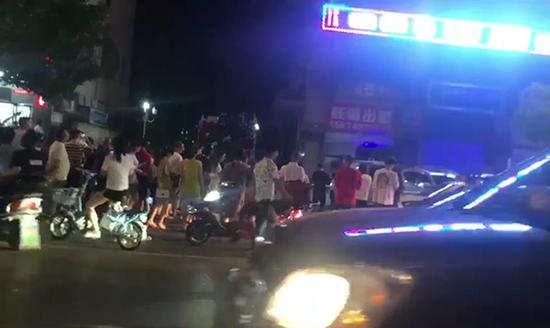 现场围观者看着楼顶。视频截图