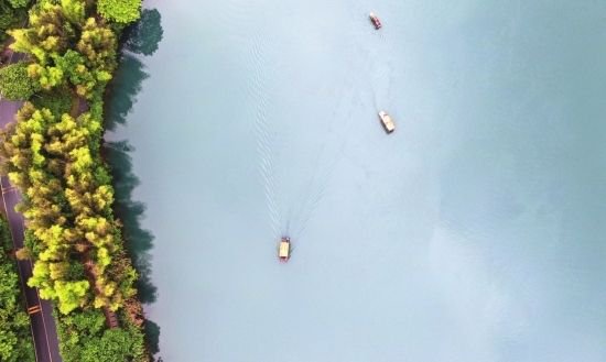 5月5日，游客乘坐游船在资兴市东江湖景区小东江景点游玩赏景。图/新华社