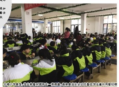 北港小学食堂，学生就餐时教师在一旁陪餐，确保食品安全以及督促学生遵守用餐纪律