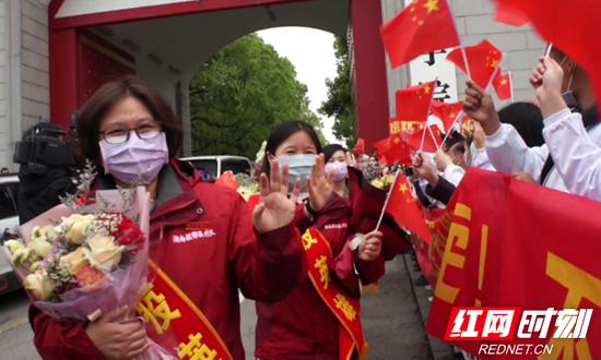 　在校教职工、留学生数百人自发在长沙医学院校门口夹道欢迎这群“最美逆行者”回家。