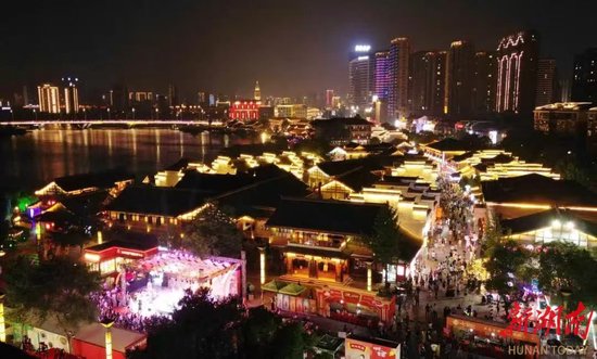 夜晚的河街,灯火璀璨,人流如织。