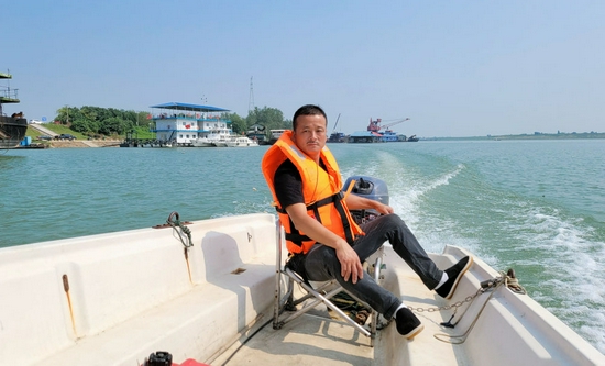 2021年9月17日，刘明安在资江驾驶巡逻船进行护渔工作。（陈樑拍摄）
