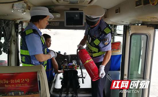 怀化交警上车检查客车灭火器等安全设施。
