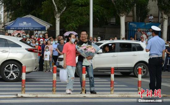 7月8日,内蒙古呼和浩特市一高考考点,考生结束考试后收到来自家长的鲜花。 中新社记者 刘文华 摄