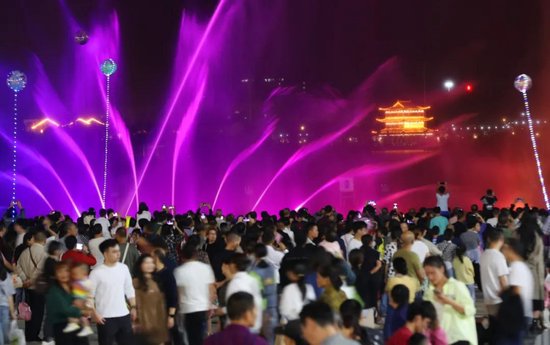 游客在衡阳市珠晖区酃湖公园观看音乐喷泉