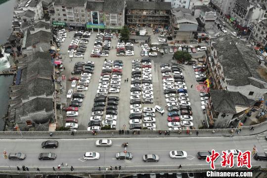 古城内一停车场停满了自驾游的私家车。　杨华峰 摄