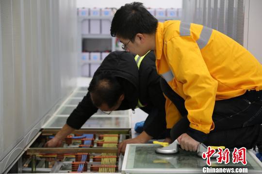 何东键和同事一起检查机房线缆连接情况。通讯员 朱琪瑞