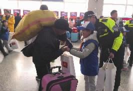 2月1日,长沙汽车西站售票大厅,长沙交警联合小志愿者向旅客赠送“平安出行”包。记者丁鹏志摄