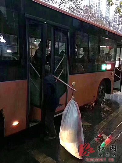 网友用手机记录下当时的情形,老人挑重物被车门夹住。