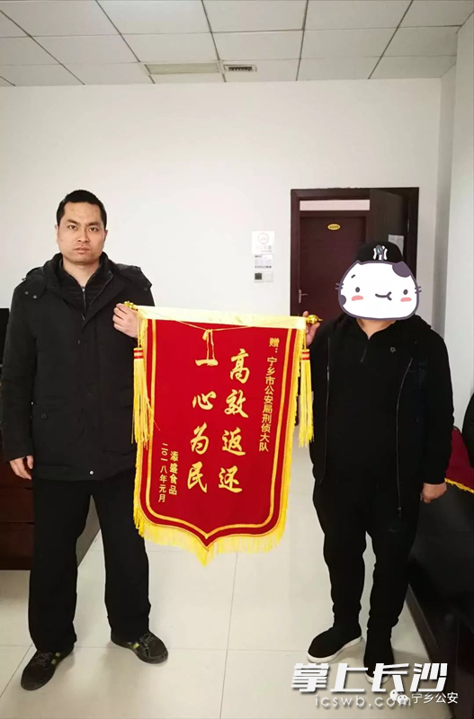 张某(右)向派出所民警送锦旗。