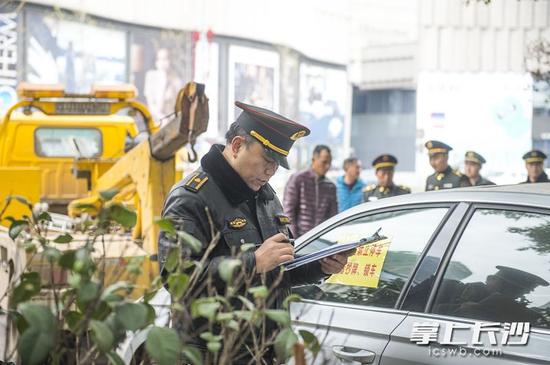 　12日上午，天心区城管执法人员与天心区交警大队民警联合执法，整治湘江风光带违停行为。