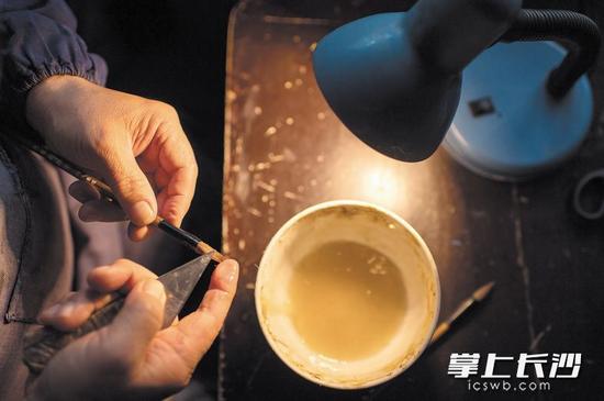 整笔让半成品毛笔沾染用海石熬制的原料,剔除毛笔中的杂毛。