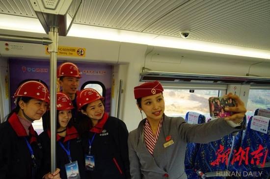 中铁二十局试乘代表与乘务员合影留念。(本组图片均由湖南日报记者徐行摄)