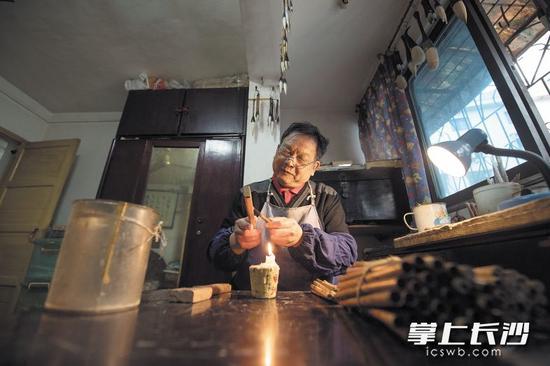 修正笔杆黄希林将笔杆在蜡烛火上烘烤之后,再用矫正工具将笔杆矫正。