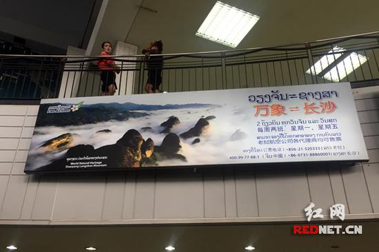 老挝万象的机场内推介两地航班和湖南张家界与崀山的广告牌。