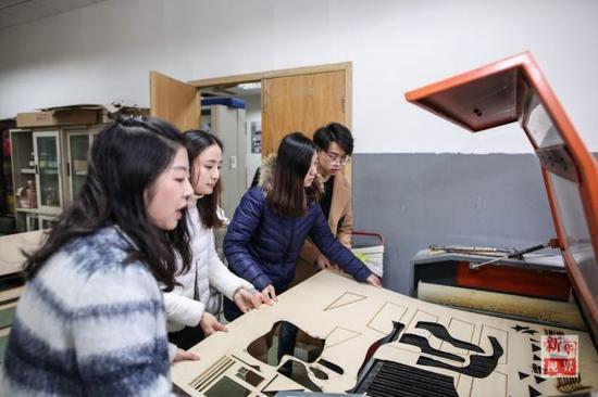 制作小组使用激光切割机切割模型材料。
