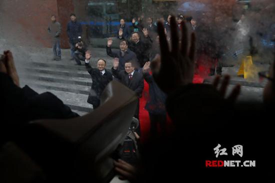 转隶干部乘坐上前去新单位报到的大巴车,依依挥别旧日领导和同事,