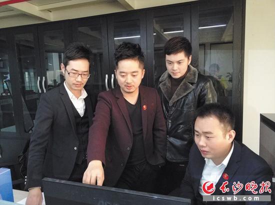 隆乾(左二)与公司里的年轻人一起交流工作。长沙晚报记者 王斌 摄