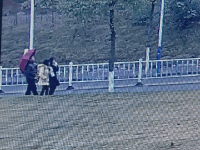 ▲ 从这段视频中我们看到,该男子撑着红色雨伞尾随一名女同学。
