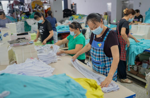 （湘银之舞车间内，员工拿成衣仔细检查。湖南日报全媒体记者李健摄）