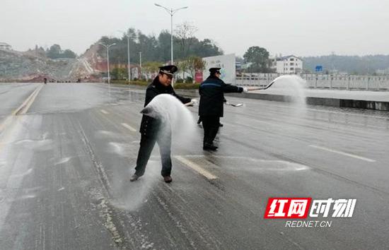 公路部门人员正在为道路撒盐除冰。