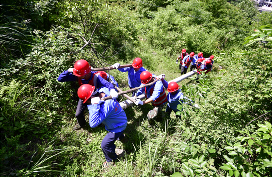 偏远山村,电信工程建设人员抬着信号杆上山