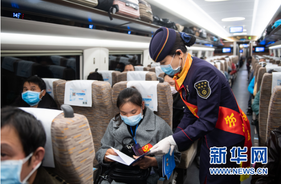2月24日,在G9628次专列上,列车工作人员为返岗复工人员提供答疑服务。