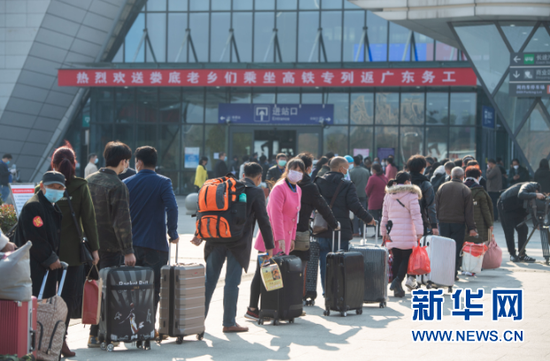 2月24日,在娄底南站,返岗复工人员排队进入火车站。