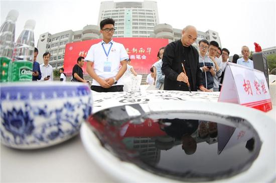 南华大学在红湘校区南华广场举办 “辉煌新时代•奋进新南华”师生红色书法笔会活动。