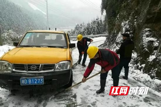 工作人员清除路面冰雪障碍。