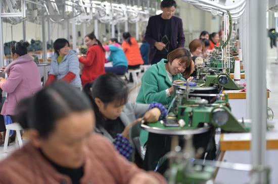3月13日，东安伟丰服饰员工赶订单、忙生产。 东轩 摄