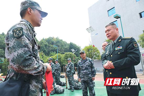 衡阳警备区司令员耿保民（右一）与民兵连长亲切交谈，详细了解民兵基本情况。