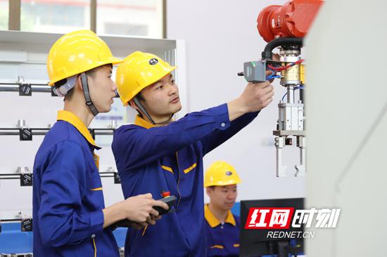 衡阳技师学院肖尹(右)、朱江(左)、刘康(中)为2018年第二届全国智能制造应用技术技能大赛全国赛做准备。周文晋 摄