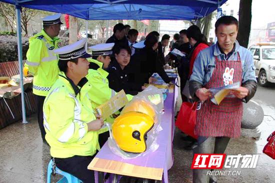 民警向市民免费发放摩托车安全头盔。