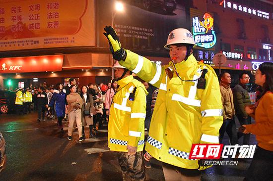 交警利用口哨、手势指挥车辆和行人有序通行。