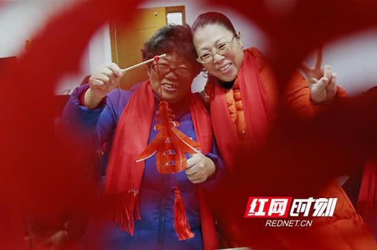 居民向镜头展示剪纸作品。