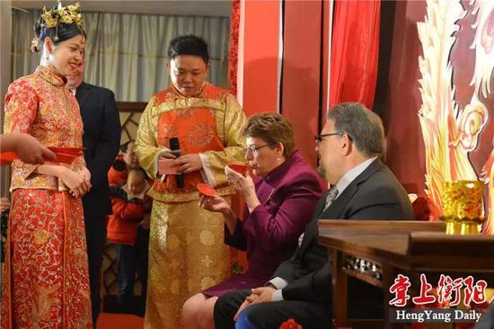 ▲新娘子秦兰婷用普通话和英语,分别向美国的洋公公洋婆婆敬茶,公公婆婆也分别回报给新娘子一个大红包。