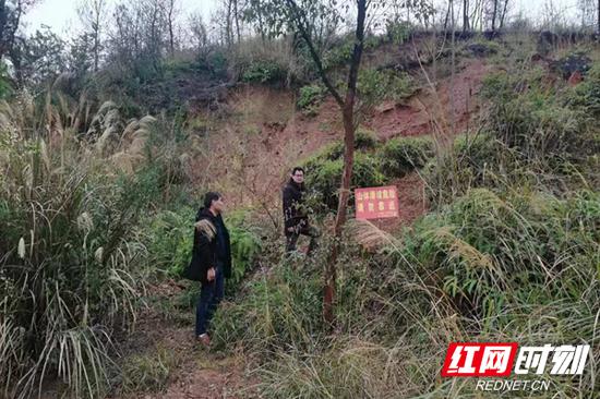 道县梅花镇政府工作人员到地质滑坡点巡查。