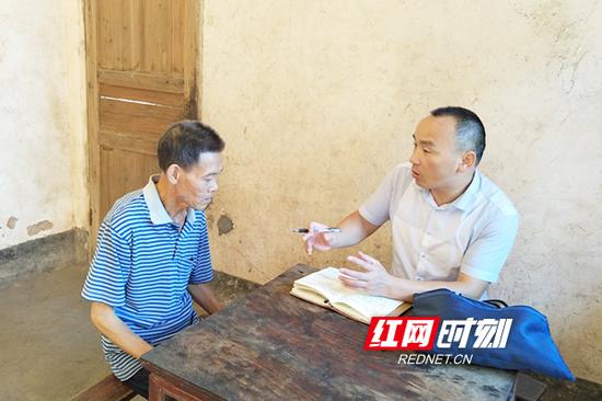 扶贫工作队队长王珍生在贫困户何国家中了解情况。