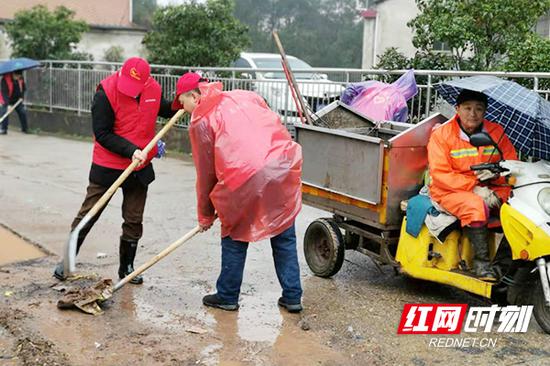 联合街道杨柳村的党员干部、“衡阳群众”志愿者队伍等穿着雨衣，拿着火钳、铁铲走进该村清除垃圾。