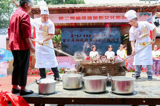 大锅鼎开启,厨师正在分装鱼汤。