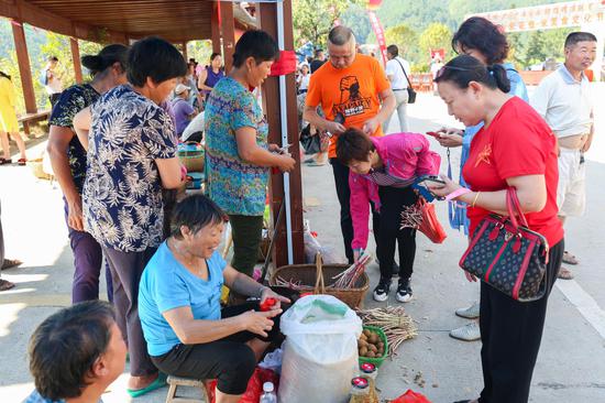 游客购买当地特色农产品。