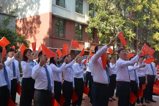 (今年10月1日,该校师生在学校举行与天安门同升国旗活动)
