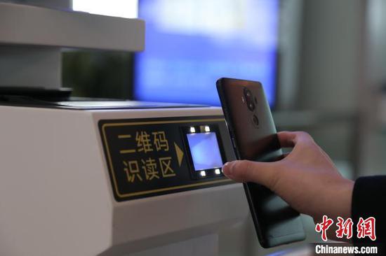图为旅客使用客票二维码检票乘车。翟灏 摄