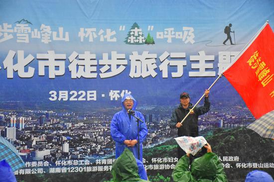 湖南省政协副主席、怀化市委书记彭国甫(图左)为“徒步雪峰山 怀化‘森’呼吸”2020年怀化市徒步旅行主题活动授旗,并宣布活动正式启动。