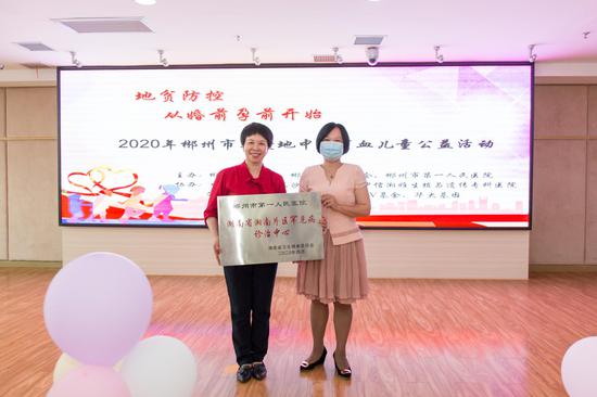 郴州市卫生健康委主任周汶(右)授予郴州市第一人民医院“湖南省湘南片区罕见病诊治中心”。