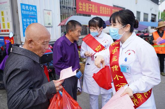 医务人员为来往群众发放宣传手册